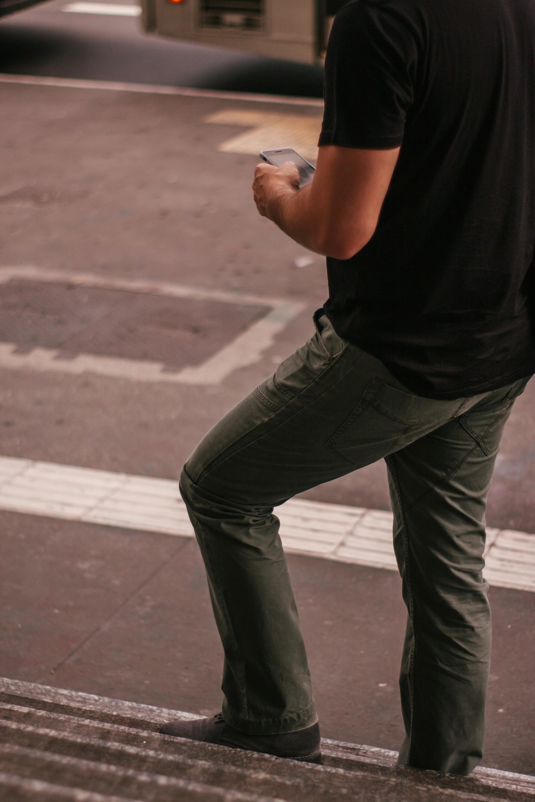 Man standing on urban staircase with phone in São Paulo street.